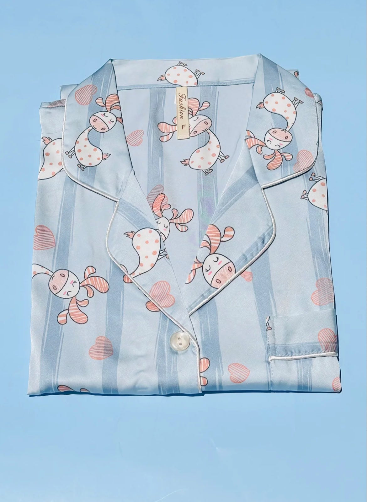 Light blue pajama top with cartoon designs on a matching fabric background